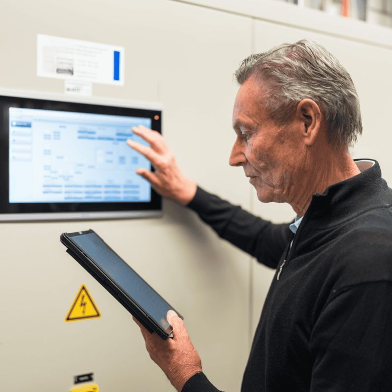 Mitarbeiter mit Notepad an der Technik-Konsole der Gebäudeautomation