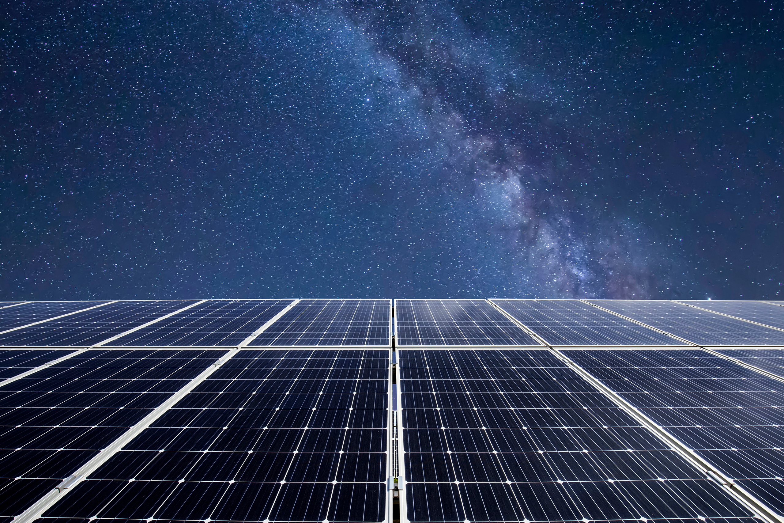 Bild von Photovoltaikpanels und darüber der nächtliche Sternenhimmel